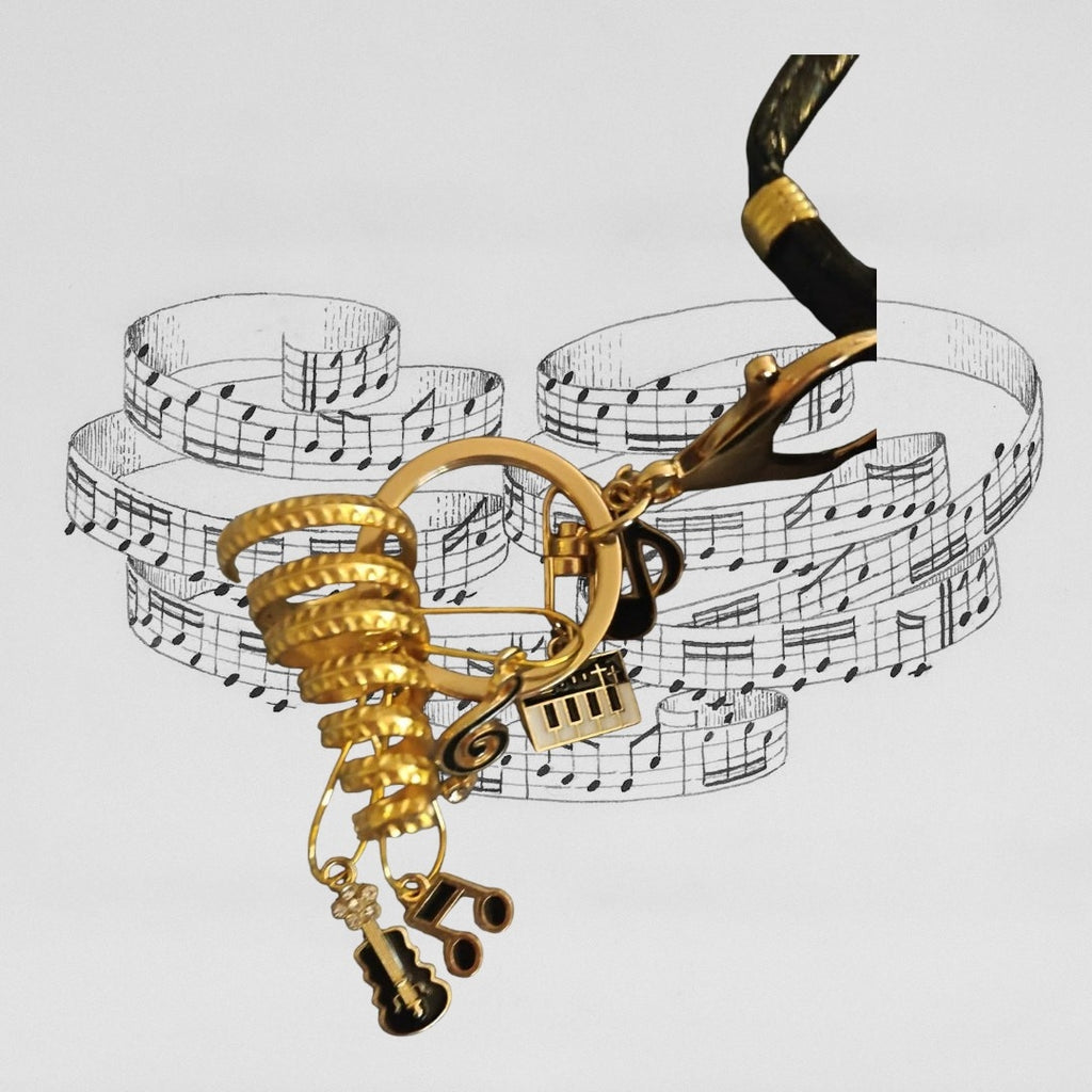 Black and Gold shoulder bag with musical bag charm.